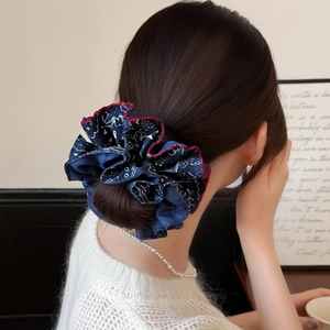Navy blue paisley pattern oversized scrunchie with red wavy edge on a high bun