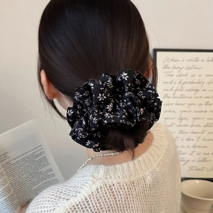 French retro black floral scrunchie in a low bun hairstyle with elegant soft chiffon fabric