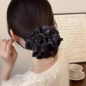 French vintage double-layered black floral scrunchie worn on a high bun hairstyle