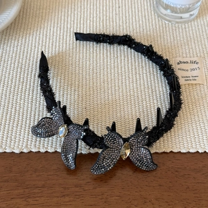 Détails des strass étincelants sur le serre-tête papillon avec peigne antidérapant