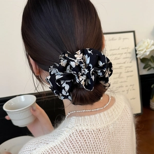 Elegant oversized black and white floral scrunchie hair tie with pleated chiffon texture