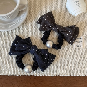 Chouchous à pois avec nœud et perles argentées sur un tapis beige de style français