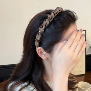 Cerchietto in raso intrecciato con perle metalliche indossato da una modella