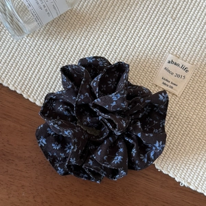 Close-up of floral double-layered scrunchie with blue patterns on brown fabric