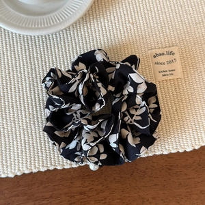 Floral chiffon scrunchie with white leaf patterns and an elegant pearl accent detail