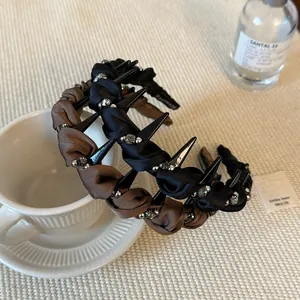 Dettaglio di cerchietto in raso intrecciato con strass e denti antiscivolo in stile elegante