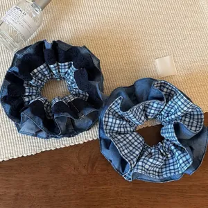 Vintage blue plaid and denim lace scrunchies on a wooden table with textured mat