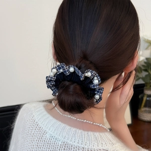 Elegant navy blue plaid scrunchie with white pearl accents on a stylish bun hairstyle