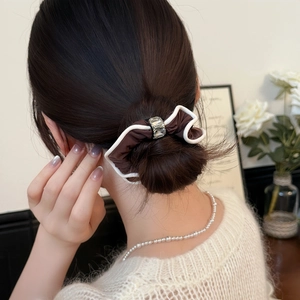 Élastique à cheveux marron avec nœud et cristal porté dans un chignon élégant