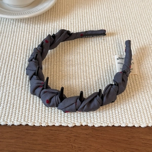 Dettaglio cerchietto in tessuto grigio con cuori rossi e denti a pettine antiscivolo