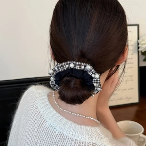Elegant black satin hair scrunchie with plaid ruffle edge and pearl details worn by model