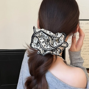French style black and white lace floral scrunchie shown on a high ponytail for women