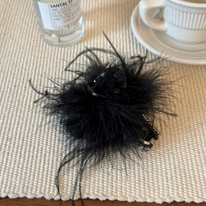Détail d'une pince à cheveux élégante en plumes noires avec strass scintillants