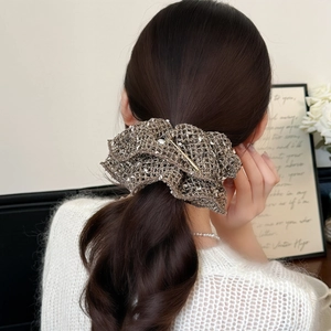 Elegant bronze hollow knit hair scrunchie with pearls worn on a stylish low ponytail