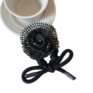 Chic knit flower hair scrunchie with black bow on white background with teacup