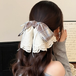 Elegant lace and plaid bow hair clip shown on a model hair for a vintage stylish look