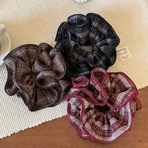 Three-piece set of layered ruffle plaid scrunchies in brown, grey and red vintage patterns