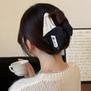 Pince à cheveux noeud contrasté noir et blanc avec étiquette chien et bouton décoratif