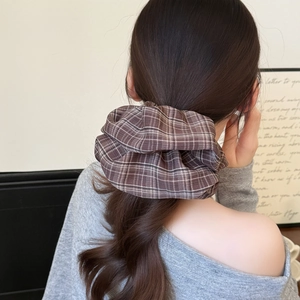 Brown plaid fabric scrunchie shown in a ponytail hairstyle for a classic vintage look