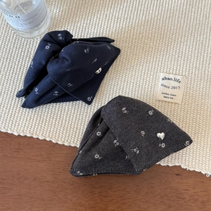 Detail of floral fabric hair claws in navy blue and dark grey with silver heart accents