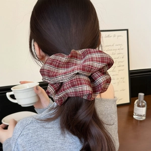 Classic red plaid oversized scrunchie for women shown on a model in a cozy home setting