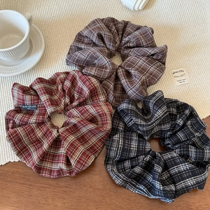 Three vintage plaid fabric scrunchies in brown red and black for elegant hairstyles