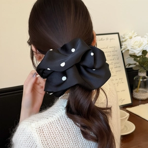 Chouchou en satin à pois noirs et blancs style français sur une queue de cheval basse
