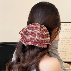 Close-up of red and white plaid hair scrunchie worn on a ponytail hair style