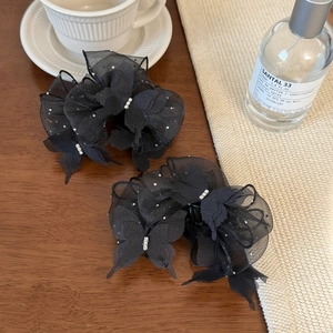 Elegante schwarze Seersucker Schleife Haarklammern mit Kristalldetails auf Holztisch