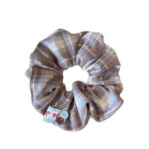 Checkered plaid scrunchie with colorful buttons and a bow tag in a white background
