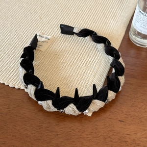 Detail of twisted knit headband with velvet fabric, pearls, and metallic punk studs