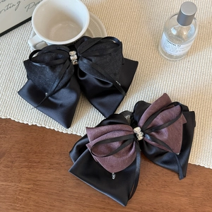 Elegant satin bow hair claws with crystals in black and purple for sophisticated styling