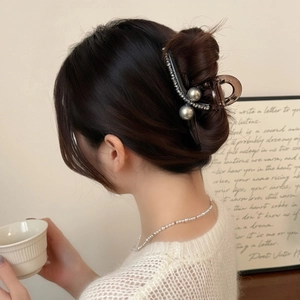Eleganter Haarklammer aus Acryl mit grauen Perlen und Strasssteinen auf braunem Haar