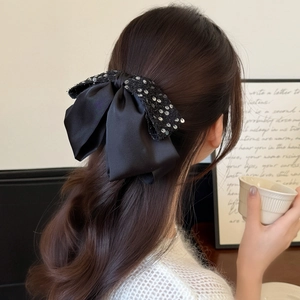 Eleganter großer schwarzer Pailletten-Schleifen-Haarclip gestylt auf langen welligen Haaren