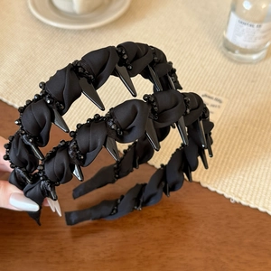 Detailed view of black beaded twist headband with unique punk spikes and fabric texture