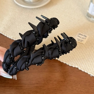 Detailed close-up of a black beaded shark hair claw clip with woven fabric and anti-slip teeth