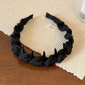Close-up of black beaded twist headband with non-slip teeth and gothic fabric texture