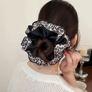 Large leopard print and black silk scrunchie shown on a bun hairstyle with soft lighting