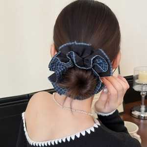 Chouchou élégant en tissu noir avec bordure à carreaux bleus sur coiffure classique