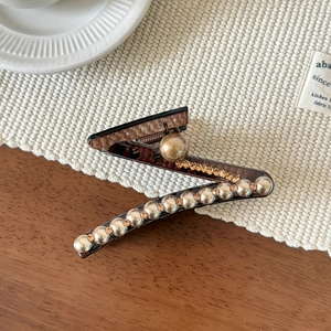 Dettaglio della molletta per capelli a Z ambra con perle dorate e strass fini