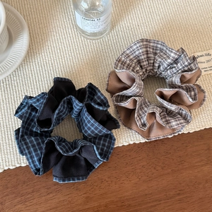 Chouchous élégants en tissu à carreaux bleus et marrons sur un tapis tressé