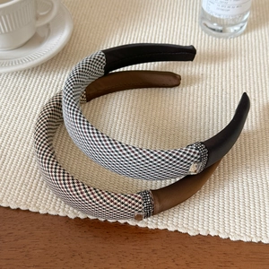 Detailed view of plaid and satin headbands featuring rhinestones and a square crystal
