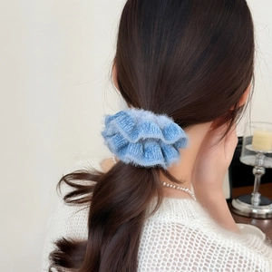Detail of light blue fluffy handmade knitted scrunchie worn on a high ponytail style