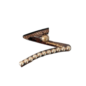 Pinza per capelli marrone a forma di Z con perle sintetiche e strass su sfondo bianco