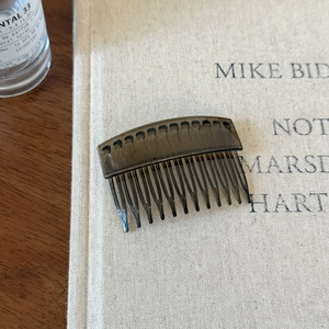Close-up of a brownish translucent resin hair side comb for neat hairstyle fixing