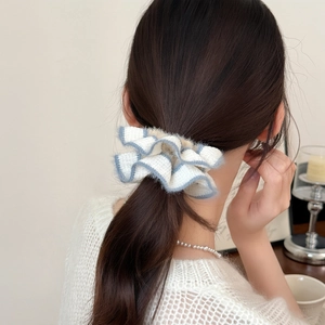 Close-up of blue and white checkered knitted hair scrunchie styled on a ponytail