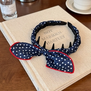 Detail of polka dot headband with red-stitched bow and non-slip inner teeth