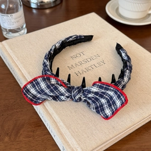 Detail view of navy plaid headband with small hair clips for braided hair styling