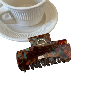Elegant tortoiseshell acetate hair claw clip with blue accents and gold spring hardware