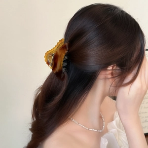 Elegant amber tortoiseshell shark clip with wavy edges for hair styling and volume
